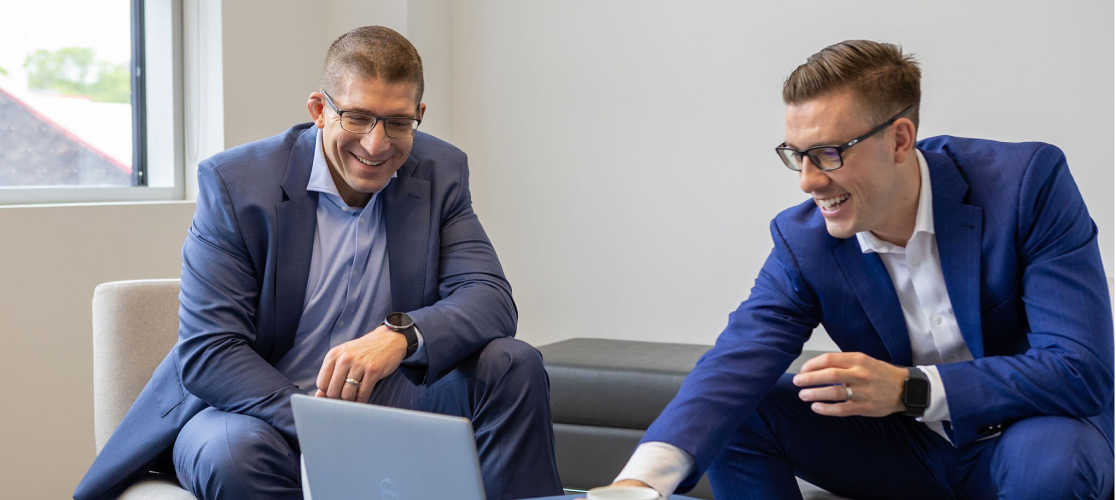 Will Simpson and Greg Wise of Aretec Wealth, looking at a laptop